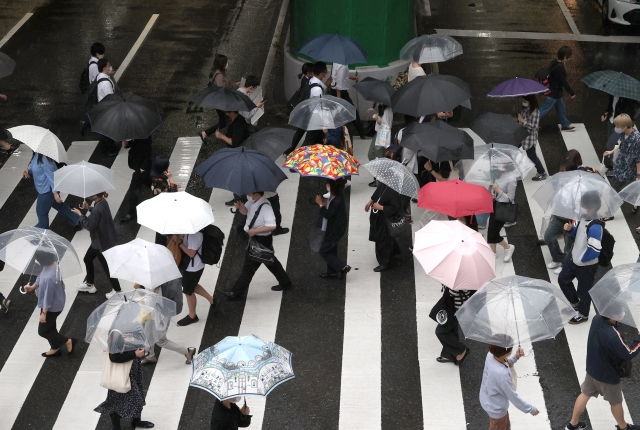 雨の中通勤する人たち